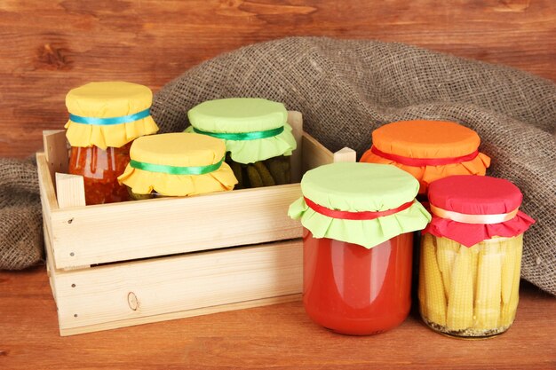 Jars with canned vegetables on wooden background closeup