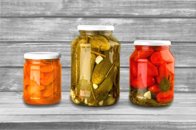 Jars with canned vegetables on wooden background