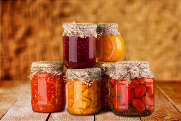 Jars with canned vegetables on wooden table