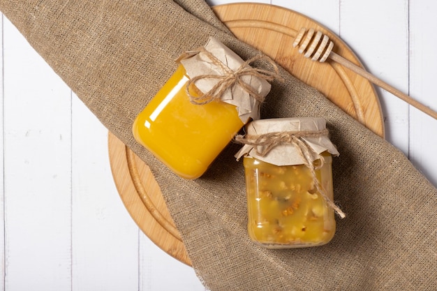 Jars with honey and nuts honey on wooden background top view flat lay