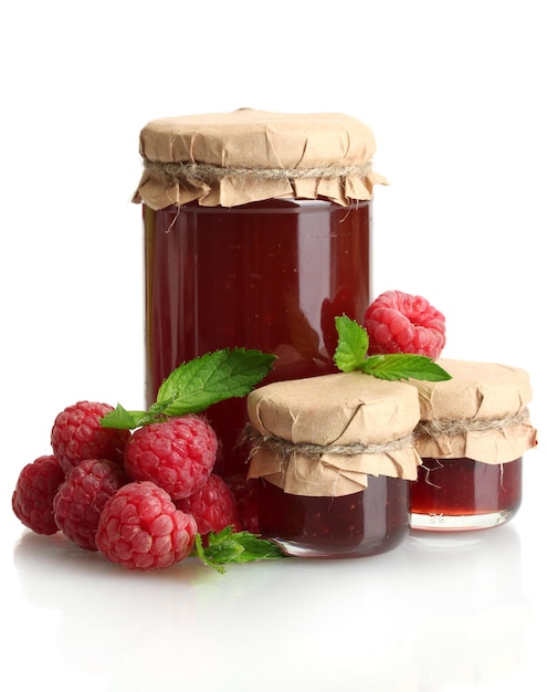 Jars with jam and ripe raspberries with mint isolated on white