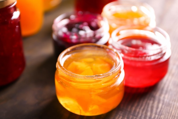 Jars with sweet jams on table