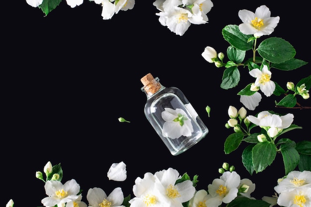 Photo jasmine flower with essence bottle over black