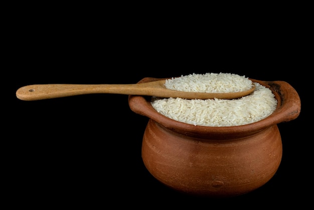 Ясминный рис в глиняном горшке и деревянная ложка