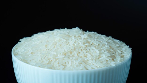 Jasmine rice popular rice variety in Thailand Rice grain that has passed through the polishing process Ready to be cooked or steamed White seeds on black background