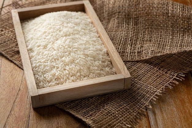 Jasmine rice seeds of thailand placed on a wood table