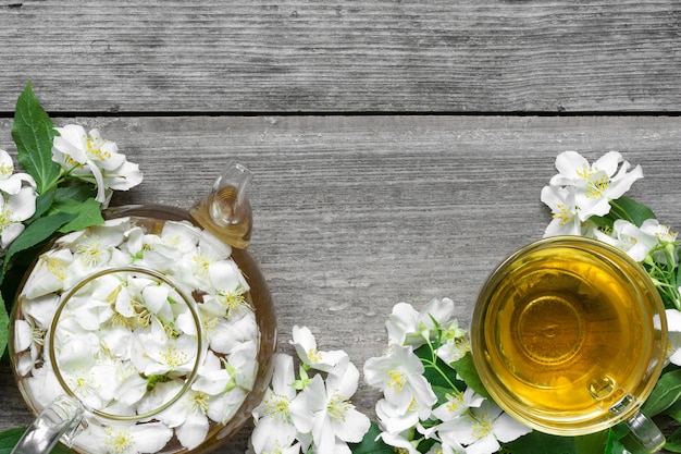 Jasmine tea with peapot and jasmine flowers on wooden background