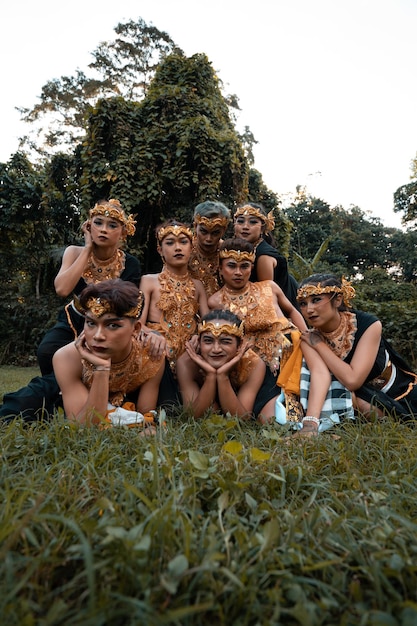 写真 写真撮影中に一緒に草の上に横たわる伝統的なダンスの衣装を着たジャワの人々