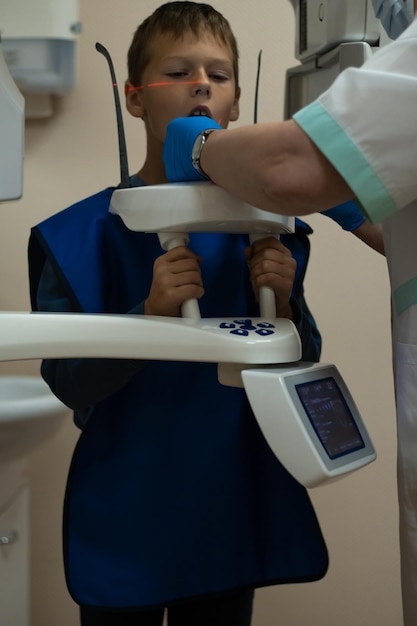 Jaw computed tomography check up teeth in dental clinic Boy in vest with open mouth on xray diagnostics CT scanning