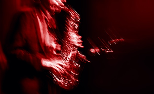 Jazz music concept. Abstract motion blurred image of saxophone player performing on stage. Sax player going crazy.