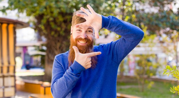 Foto je gelukkig en vriendelijk voelen en positief glimlachen en een portret of fotolijst met handen maken