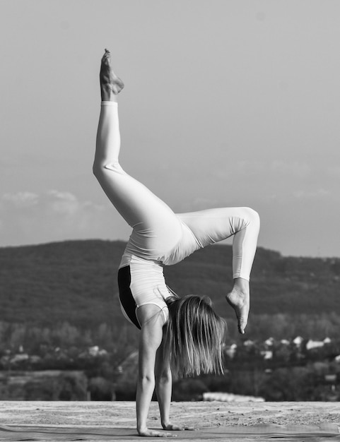 Foto je wordt gewoon sterk flexibel meisje buiten vrouw die yoga beoefent spieren strekken fitnesstrainer vrouw voert gymnastische prestaties uit acrobatische gymnastiek gymnastiekatleet het wordt nooit gemakkelijker