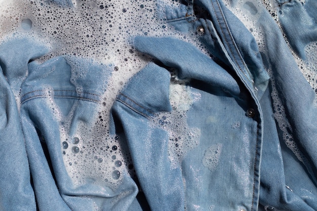 Camicia di jeans ammollo in dissoluzione acqua detersivo in polvere, lavaggio panno concetto di lavanderia