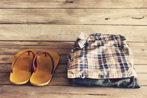 Jean and slippers on wood background