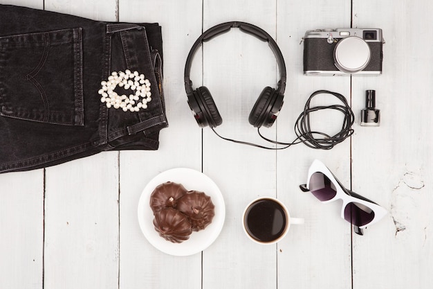 Photo jeans camera headphones sunglasses and coffee on white wooden desk