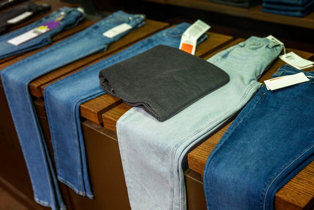 Photo jeans of different colors and patterns lie on the table in the store top view style fashion and comfort