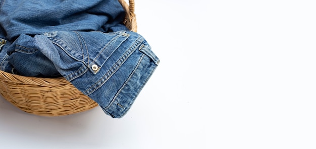Jeans in laundry basket on white background.