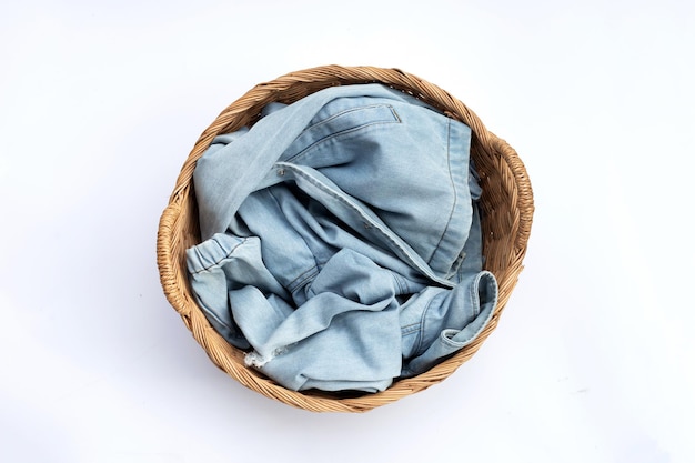 Jeans in laundry basket on white background.