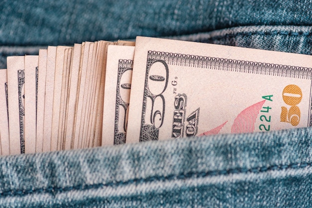 jeans met Amerikaanse dollarbiljetten in een zak. Dollar in spijkerbroek. Financieel begrip.