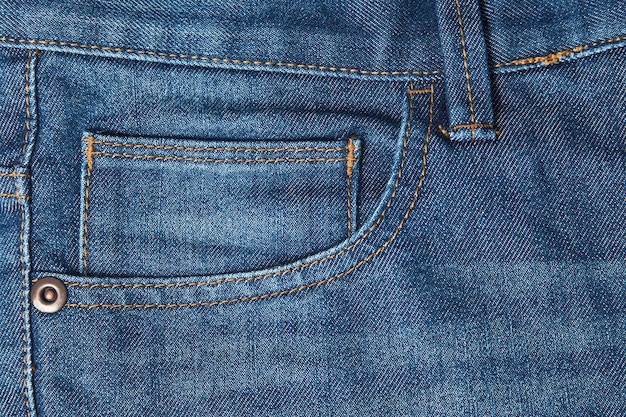 Карман джинсов крупным планом, вид спереди. Синий фон текстуры джинсов
