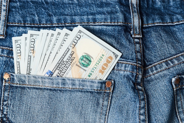 Tasca dei jeans con soldi, primo piano. tasca dei blue jeans con banconote da cento dollari