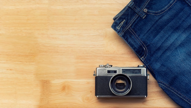 Jeans e macchine fotografiche retrò poggiano sul pavimento di legno