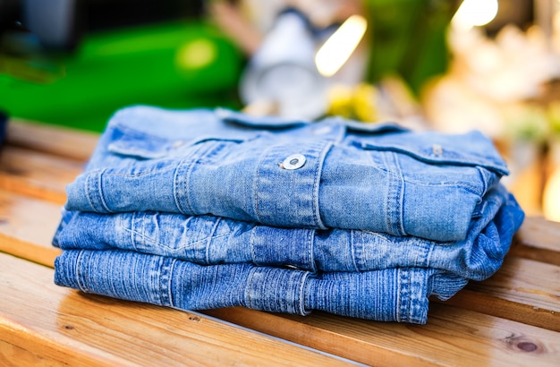 Jeans shirt. Rolled-up denim shirts lie on the counter in the store.