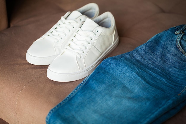 Jeans and sneakers on brown background.