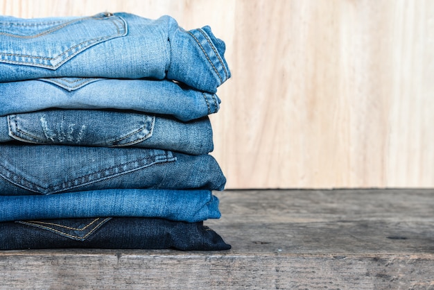 Jeans stacked on a wooden table