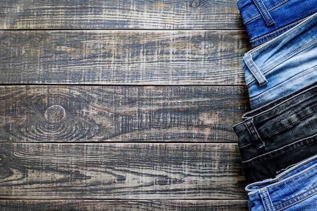 Jeans trousers on a rustic wooden background with copy space Variety of comfortable casual trousers top view