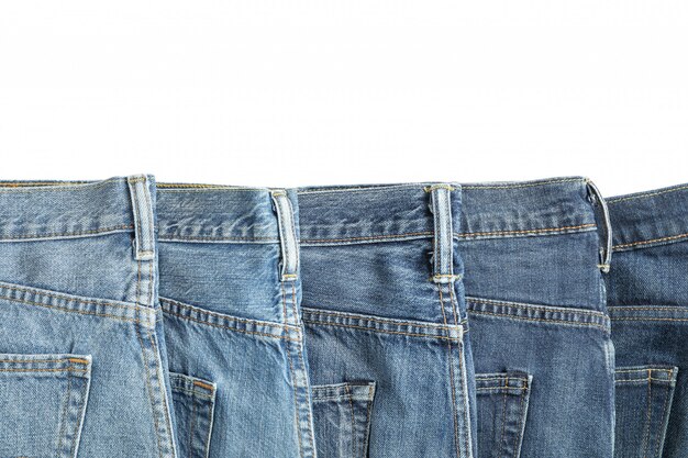 Jeans van verschillende kleuren die op witte achtergrond worden geïsoleerd