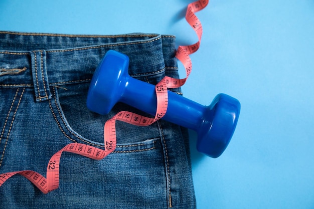 Jeans with measuring tape and dumbbells