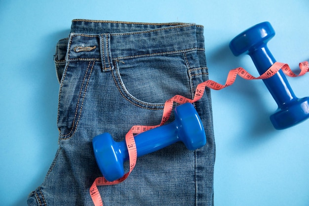 Jeans with measuring tape and dumbbells