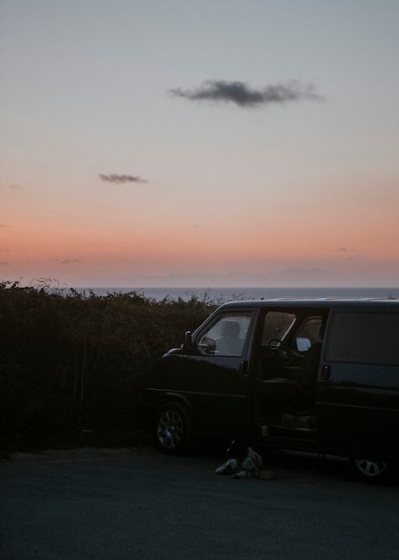 Jeep su una spiaggia sotto un cielo arancione