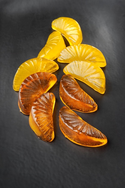 Jelly citrus candy on a black dish on a dark background