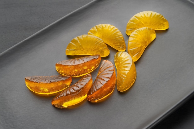 Jelly citrus candy on a black dish on a dark background