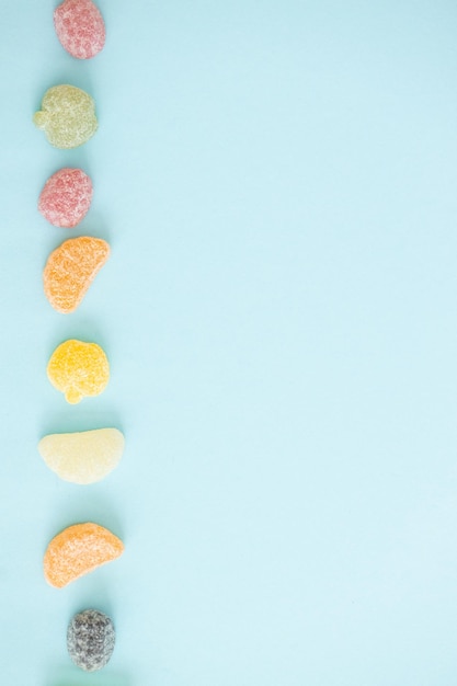 Jelly color fruit sweets on blue background