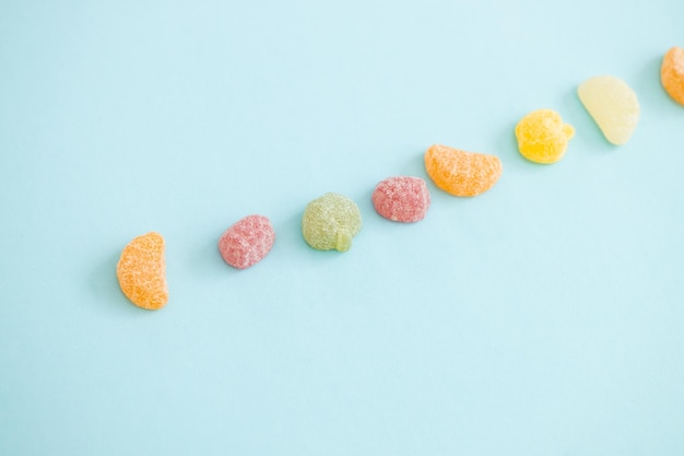 Jelly color fruit sweets on blue background