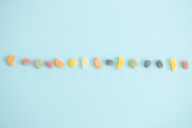 Jelly color fruit sweets on blue background