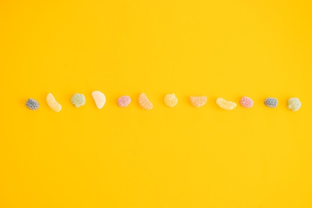 Jelly color fruit sweets on yellow background