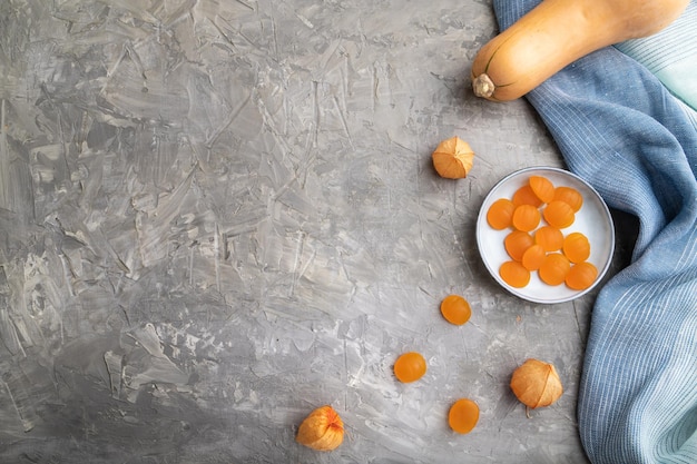 Jelly pumpkin candies on gray concrete background copy space top view