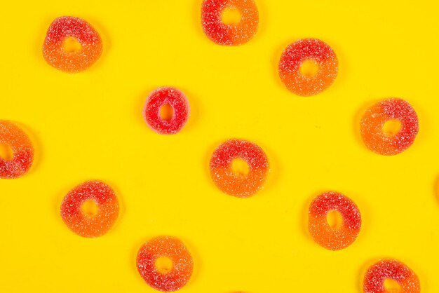 Jelly sweets rings on yellow background pattern