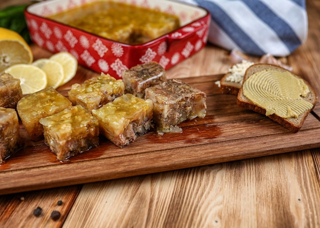 Jelly with meat, beef aspic, traditional Russian dish, portion on a plate, mustard and horseradish