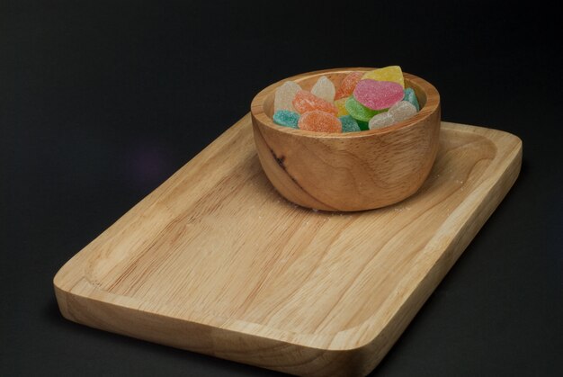 Jelly in a wooden tray has a black background.