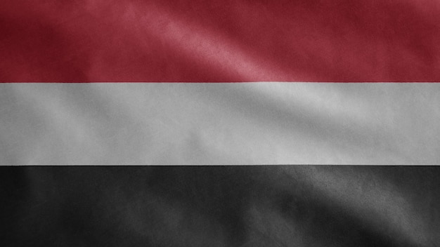 Jemenitische vlag wappert in de wind. jemen sjabloon blazen, zachte en gladde zijde. doek stof textuur ensign achtergrond. gebruik het voor het concept van nationale dagen en landelijke gelegenheden.