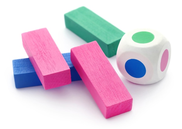 Jenga spel van kleurrijke houten blokken met dobbelstenen op witte achtergrond