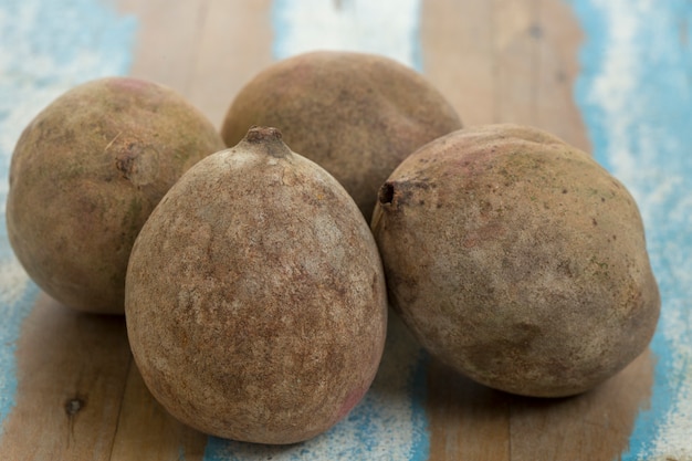 Jenipapo, fruit gebruikt in likeuren en snoepjes, op rustiek hout