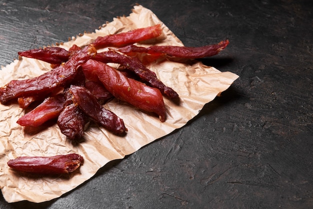 Jerky meat strips with spices and herbs on a paper