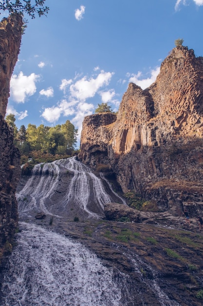 Foto jermuk cascata che scorre ruscello vista pittoresca tra le rocce del canyon gola illuminata dal sole foto d'archivio armeno
