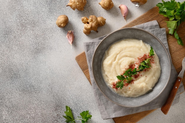 Jerusalem artichoke puree decorated fresh parsley in bowl